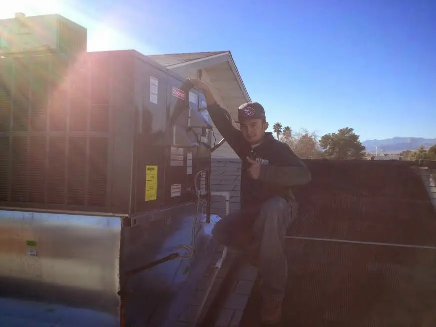 HVAC technician performing AC Tune-Up on a rooftop unit in Norwich